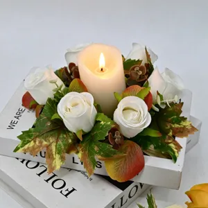 Portacandela con ghirlanda di rose e foglie d'acero autunnali per decorazione tavola