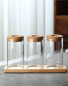 Lot de trois vases en verre transparent sur plateau en bois avec bouchons en liège