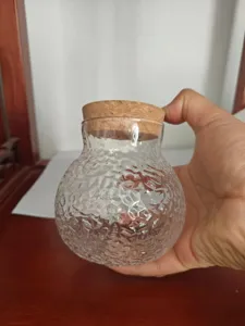 Dettaglio vaso idroponico in vetro trasparente, forma rotonda con coperchio in sughero.