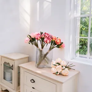 Artificial 9-head peony bouquet displayed in a glass vase on a white cabinet for home decor