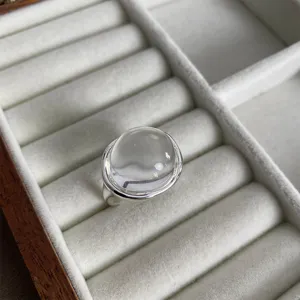 Primo piano di un anello minimalista in argento con cupola di cristallo trasparente