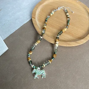 Gedetailleerd overzicht van een boheemse kralenketting met groen gestreepte zebra-hanger