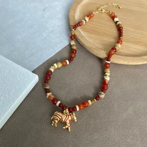 Detailopname van een Boheemse kralenketting met een gouden zebra-hanger