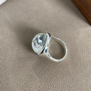 Dettaglio di un anello in argento con una grande pietra di cristallo a cupola.