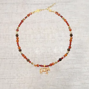 Gedetailleerde weergave van een etnische kralenketting met een gouden zebra hanger