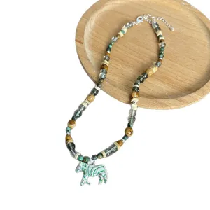 Vintage bohemien kralenketting met gestreepte zebra hanger op houten dienblad