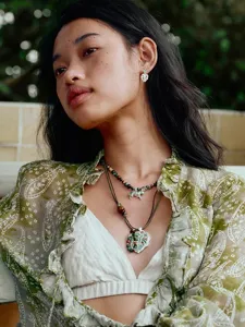 Detailopname van een retro kralenketting met zebrahanger gedragen door een model