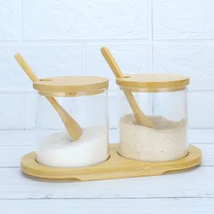 Detalle de tarro de especias de vidrio con recipientes transparentes, cucharas y bandeja.
