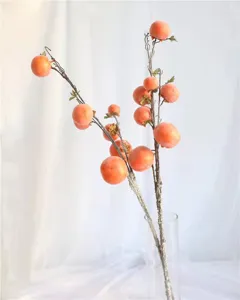 Close-up of artificial frosted persimmon branches for home interior decoration
