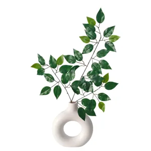 Artificial ficus branches with realistic green leaves in a modern white donut vase.