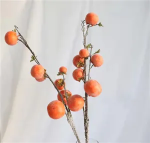 Macro view of artificial persimmon branch with realistic frosted texture for home decor