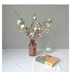 Decoratief boeket met gedroogd katoen en eucalyptus in een stijlvolle glazen vaas