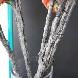 Close-up detail showing the realistic frosted bark texture of the artificial persimmon branches.