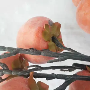 Close-up macro detail of artificial persimmon branch with realistic frost texture decor