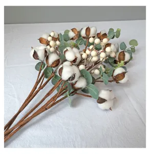 Detailopname van kunstmatige katoenbollen en witte bessen op decoratieve takken