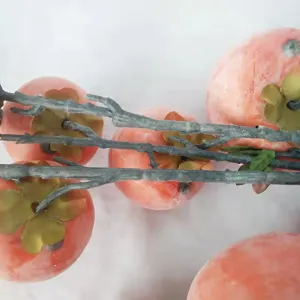 High-quality close-up of artificial persimmon branches with realistic frosted orange fruits