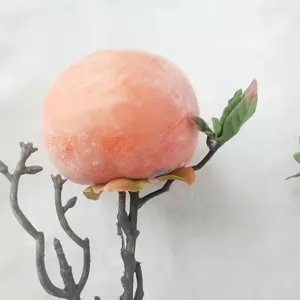 Detailed macro view of artificial persimmon fruit on a naturalistic branch for decor