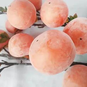 Detailed close-up of a lifelike frosted artificial persimmon fruit branch ornament for home decor