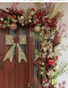 Detailansicht der Weihnachtsdekoration mit roten Beeren und goldenen Glitzerzweigen an einer Tür.