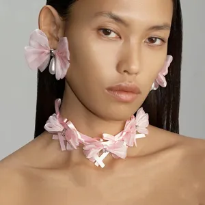 Détail d'un choker à nœud en ruban rose fait main et boucles d'oreilles assorties