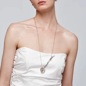 Gedetailleerde weergave van elegante zilveren madeliefje hanger ketting gedragen door model
