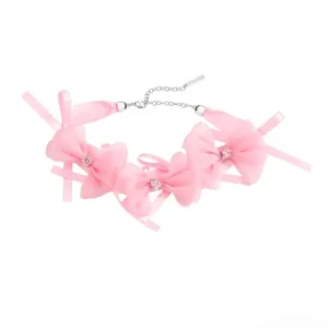 Vue détaillée d'un collier ras du cou en ruban rose avec des zircons et une chaîne argentée