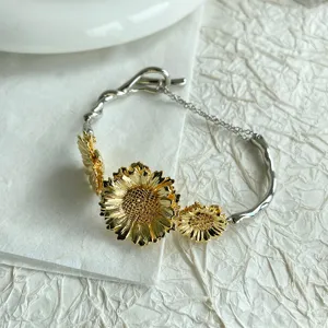 Gedetailleerd overzicht van prachtige gouden zonnebloembedels op een zilveren armband