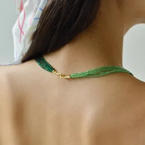 Detailansicht einer eleganten mehrreihigen grünen Perlenkette mit goldenem Verschluss