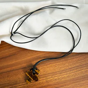 Detailed view of natural tiger's eye stone flower pendant on a minimalist black cord