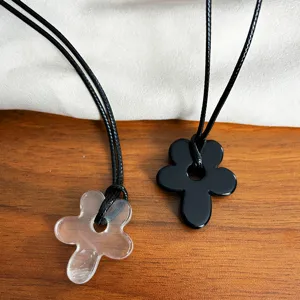 Detailed close-up showing minimalist hollow flower pendants in clear and solid black finishes