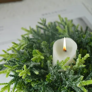 Weihnachtskranz aus gefrosteter Kiefer mit Kerze für die festliche Tischdekoration zu Hause