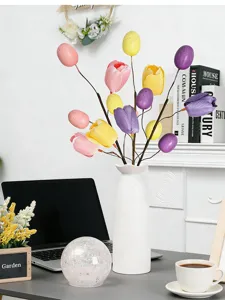 Detailaufnahme der Osterzweig-Deko mit bunten Tulpen und gesprenkelten Eiern in Vase
