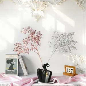 Detailed view of rose gold and silver glitter branches in a black decorative vase