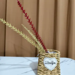 Macro detail of red and gold glitter wheat stalks placed in a rustic woven basket prop