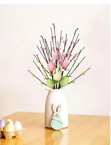 Decorative Easter egg and berry stems in a white vase for festive home decor.