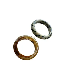 Minimalistisches Set aus bernsteinfarbenen und dalmatinerstein-artigen breiten Ringen