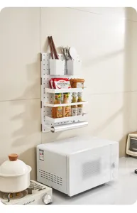 Multi-functional white plastic kitchen pegboard organizer mounted above a microwave