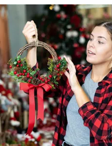 Close-up of a festive Christmas wreath with red berries, pinecones, and a red bow