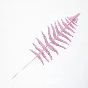 Close-up of pink glittery Persian leaf with intricate hollow design for Christmas