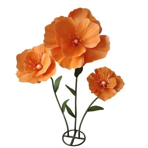 Gros plan detail des grands petales de coquelicot artificiel orange et des etamines.
