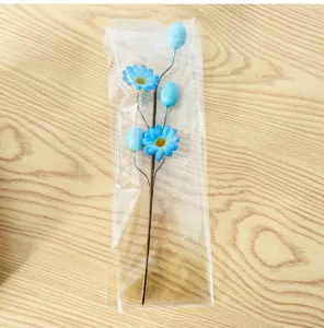 Blue Easter egg and daisy flower branch decoration in clear plastic packaging