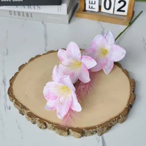 Nahaufnahme eines künstlichen rosa Lilienzweigs mit Ölgemälde-Textur auf Holzscheibe