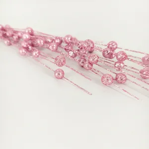 Detail view of pink glittery foam berries on stems for Christmas floral decoration.