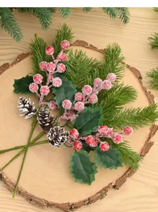 Nahaufnahme von befrorenen Weihnachtsbeeren, Tannenzapfen und künstlichen Nadeln auf Holz.
