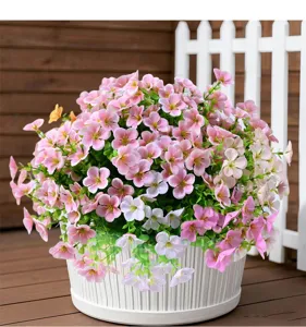 Detailed view of artificial pink and white wild flowers in a white planter for garden decor.