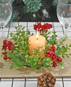 Macro view of Christmas eucalyptus candle ring with red berries on a festive table