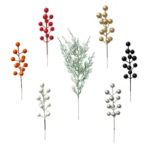 Variedad de ramas de bayas navideñas artificiales de colores y agujas de cedro nevadas