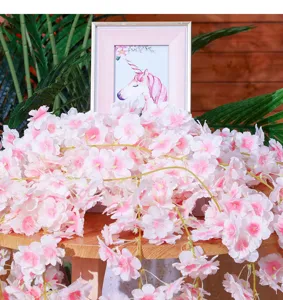 Artificial cherry blossom vine detail shot, pink silk flowers hanging decor for wedding ceiling.