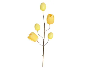 Detailansicht eines künstlichen Osterzweigs mit gelben Tulpen und gesprenkelten Eiern.