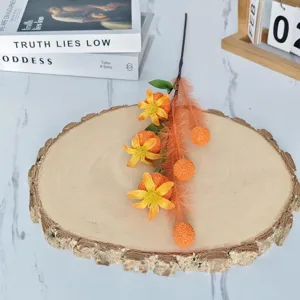 Gros plan de branches de fruits de pavot orange artificiels sur un plateau en bois